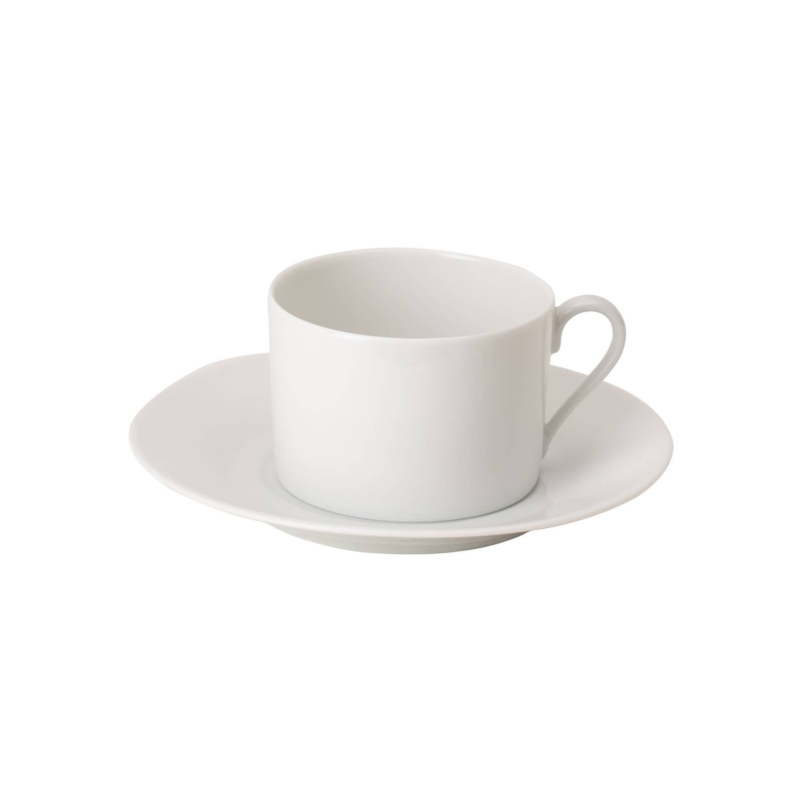 Die Limoges weiß Teetasse mit Untertasse von WEITZ ist eine zylindrische weiße Porzellantasse auf einer leicht konischen Untertasse.