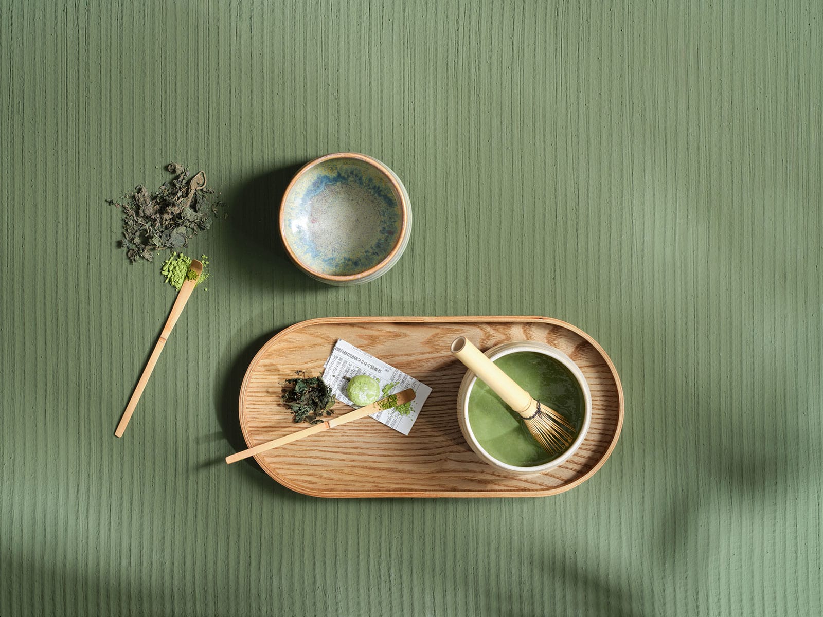 Draufsicht auf ein Stillleben der Matcha-Zubereitung mit Besen, Löffel und speziellen Schalen aus der Moribana Serie von Asa Selection.