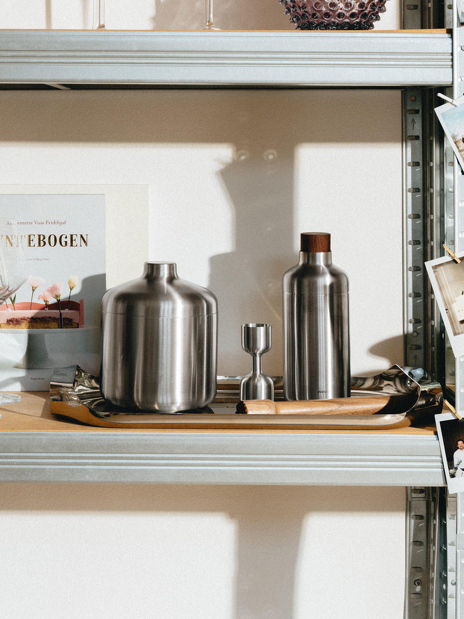 Ein Regal, auf dem sich der Liquid Lounge Cocktailshaker sowie andere Produkte der Serie befinden.