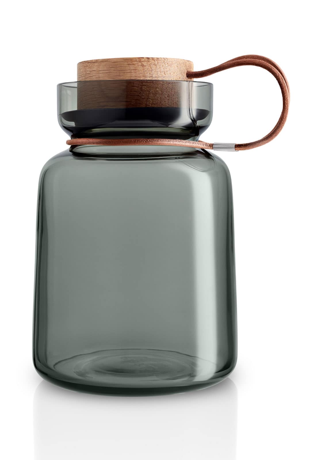 Die Silhouette Aufbewahrungsdose aus grünem Glas mit Korkdeckel und Lederriemenhalterung vor weißem Hintergrund.